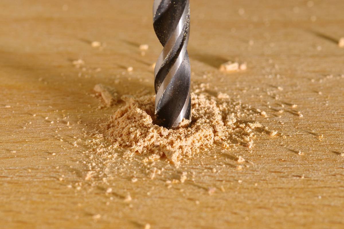 Close-up of professional nail art etching tool creating fine lines on a gel manicure