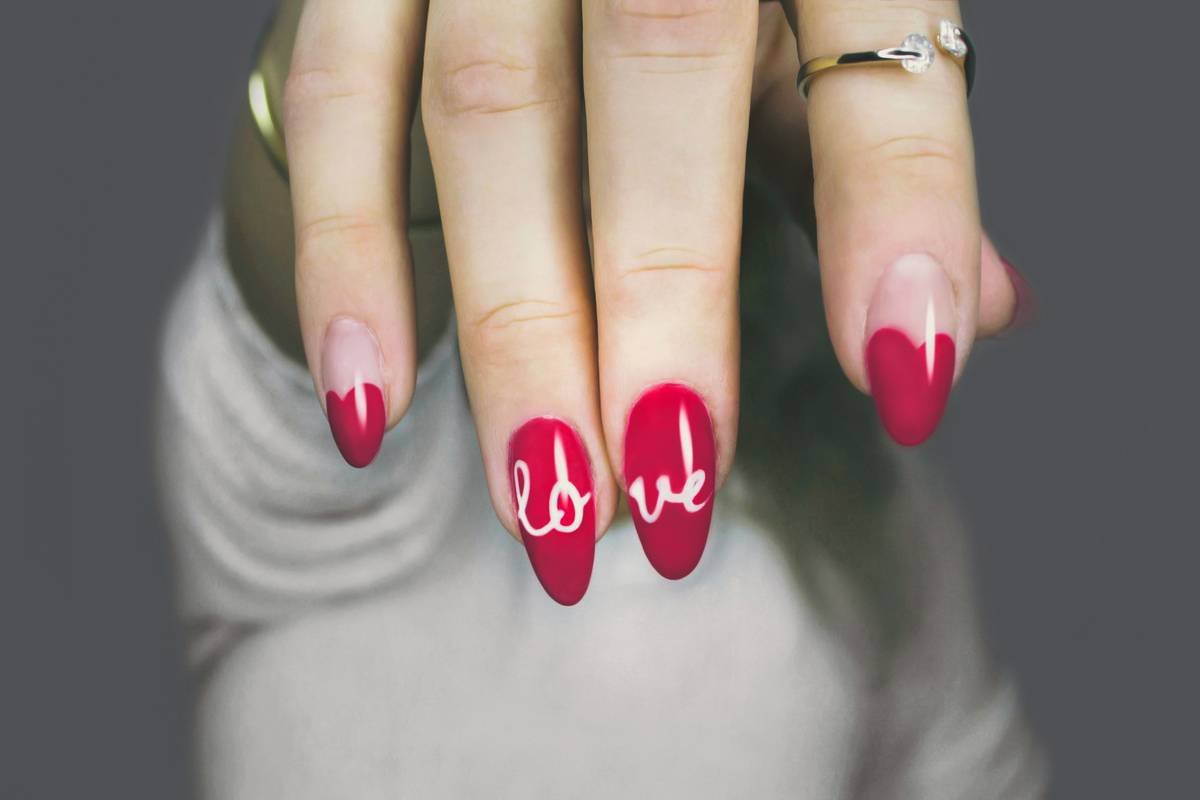 Professional nail technician using a pro nail polisher on client's nails for salon-quality finish